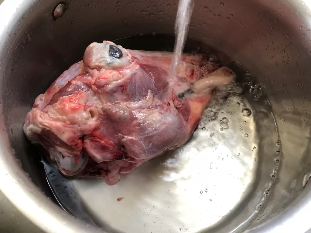 Washing raw Sheep's Head to prepare for cooking
